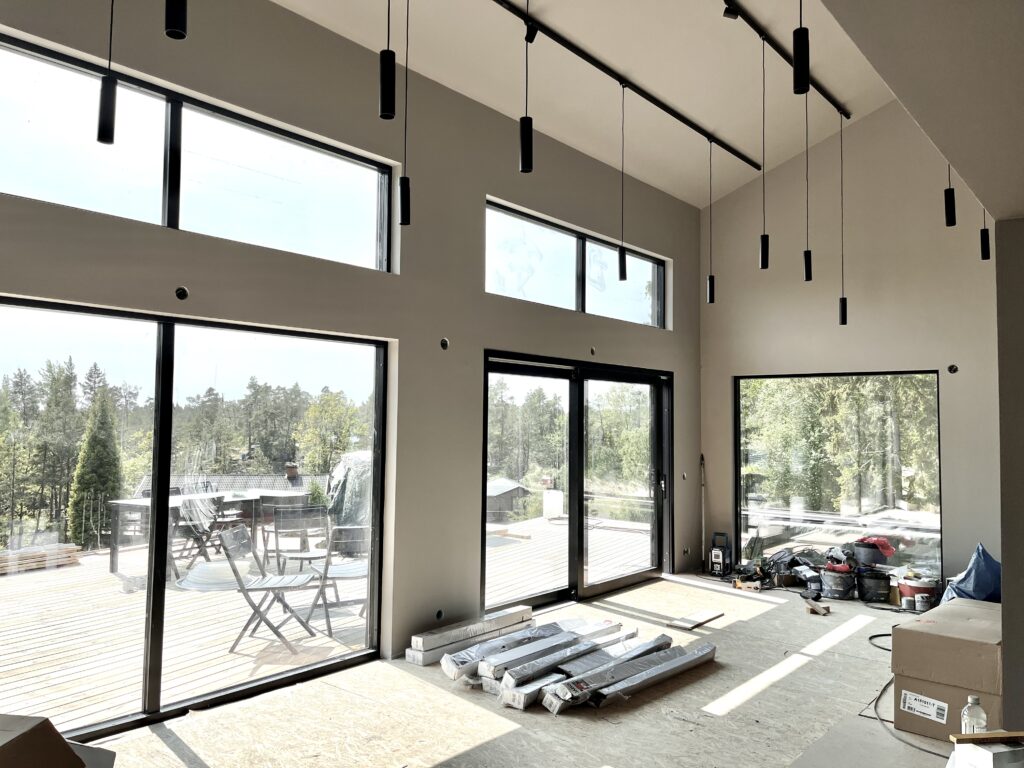 Vitt vardagsrum med stora fönster