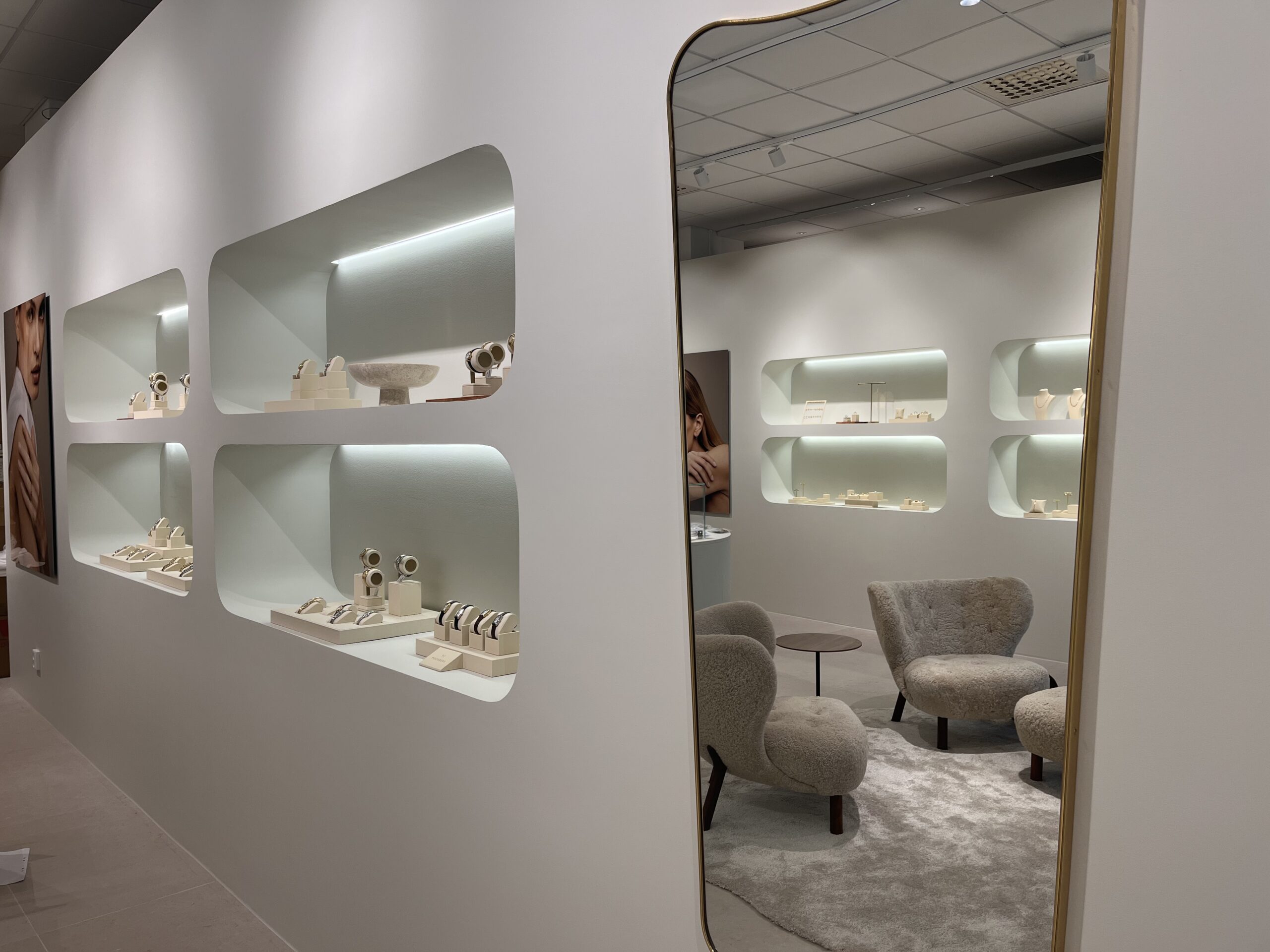 Vit vägg med spegel och inbyggda hyllor